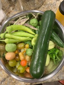 A large bowl filled with freshly harvested vegetables.